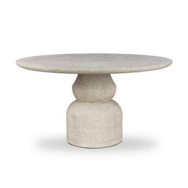 Round concrete outdoor dining table with textured top and pedestal base, aged natural.
