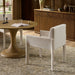 Off-white upholstered dining chair with wide arms, padded seat, and tapered legs.