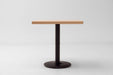 Rectangular maple table top with straight edges on a black round pedestal base
