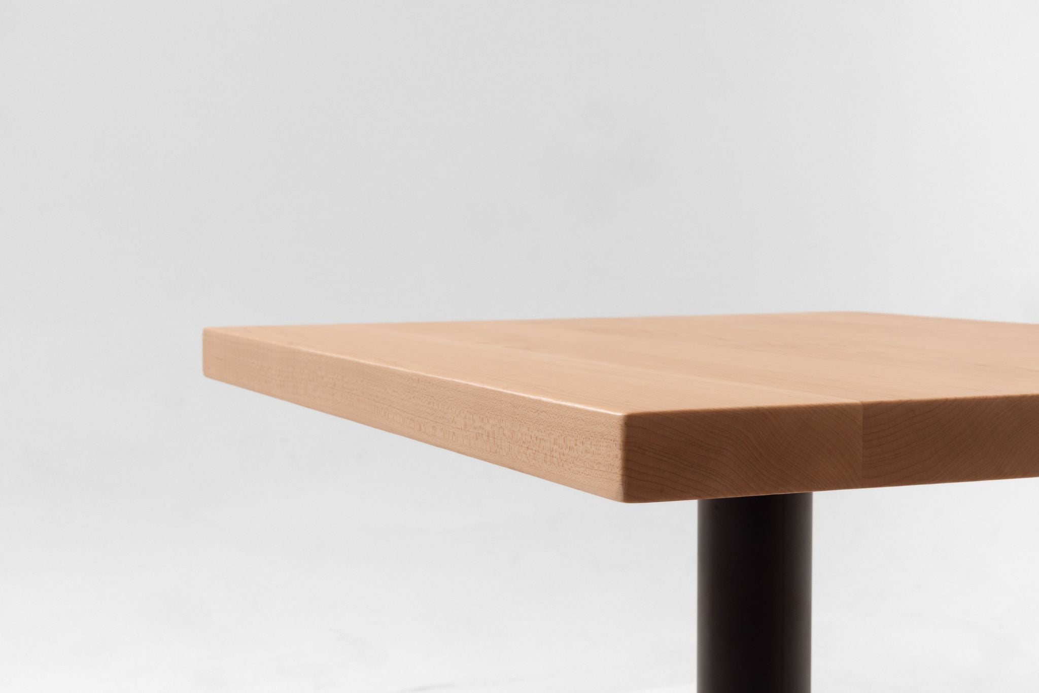Maple table top corner with smooth squared edge and visible wood grain