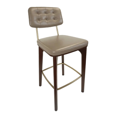 Upholstered bar stool with tufted back, beige seat, dark wood legs and gold footrest frame.