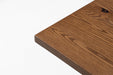Red oak tabletop corner with textured wood grain and beveled edge