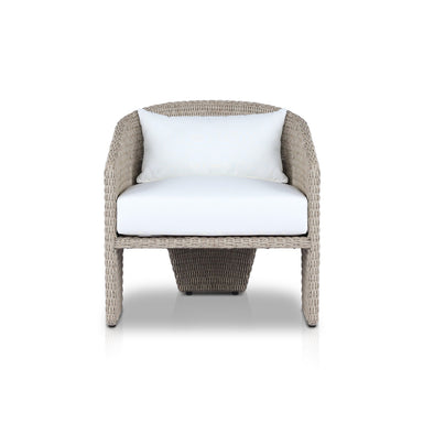 An outdoor chair with a barrel-shaped back, a white cushion, and three legs, made from all-weather wicker.