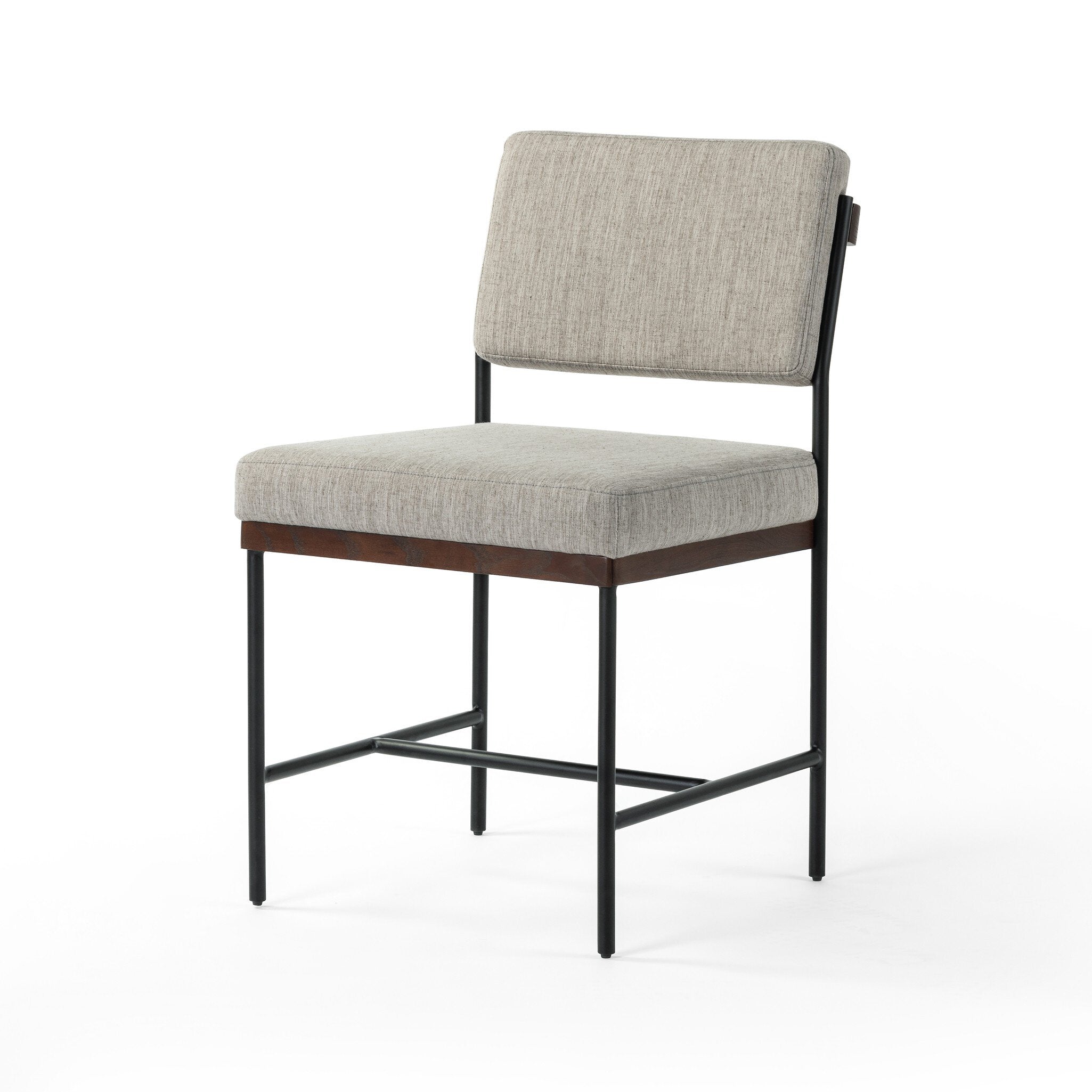 Chair with gray cushioned seat and backrest on a white background. Angled Benton Dining Chair in Savile Flannel performance fabric featuring a slim iron frame and wood bar.