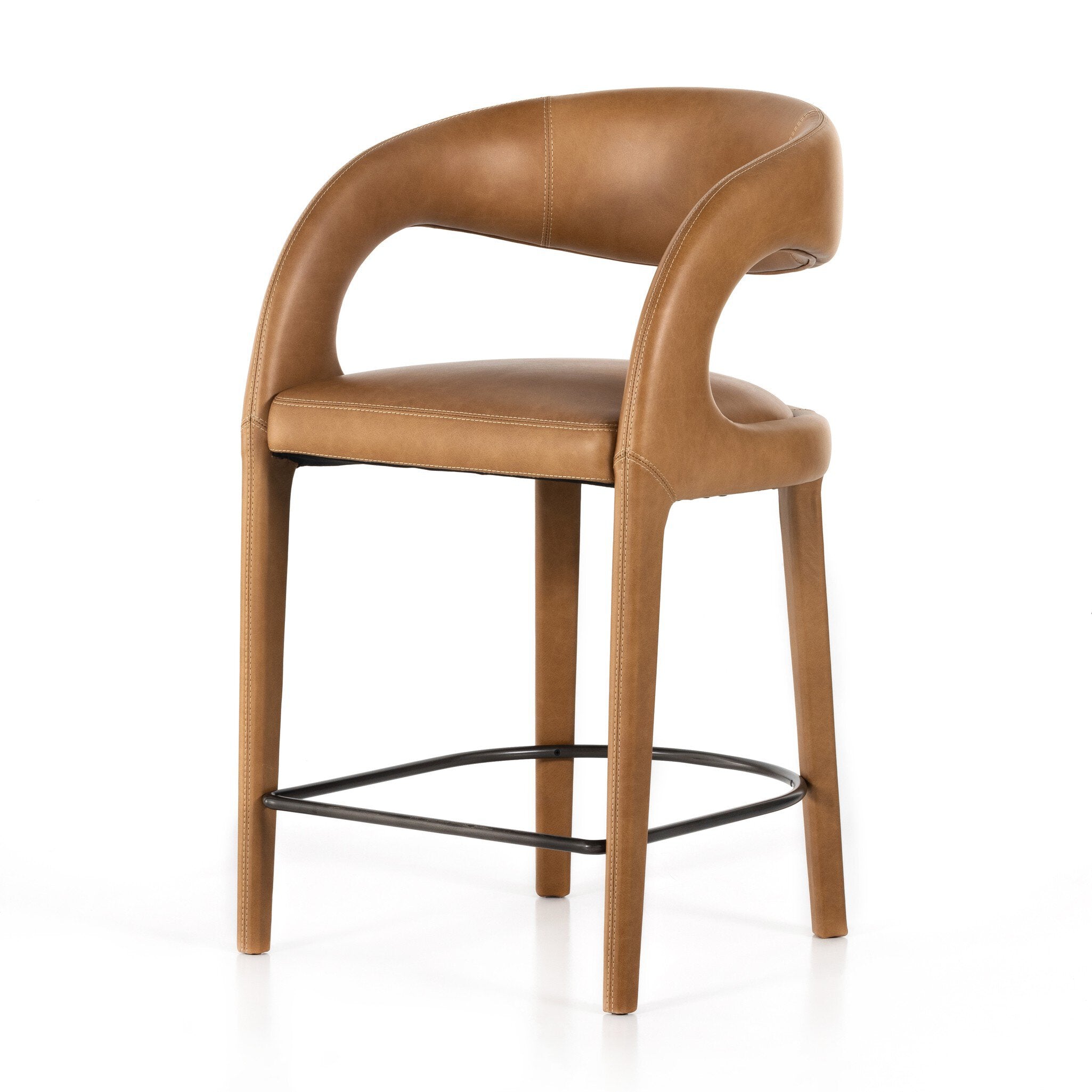 Counter stool angled view with tan upholstered seat, curved back, and black metal footrest ring.