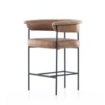 Tan counter stool with padded round seat and back, supported by black metal frame
