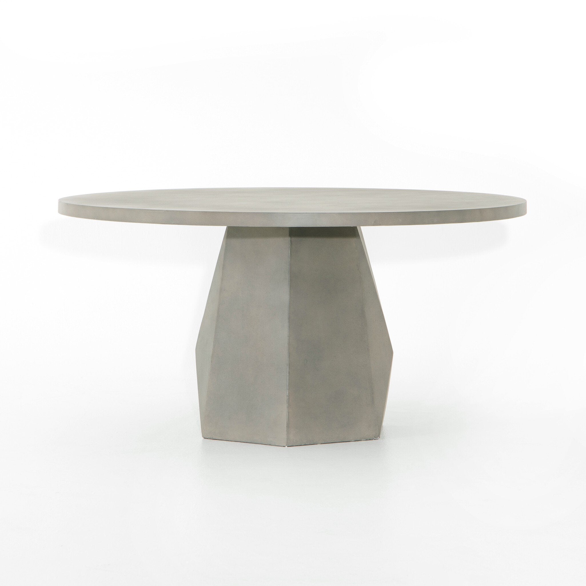 Angled Outdoor Dining Table with a round white concrete top and tapered pedestal base