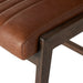 Brown upholstered cushion corner with stitched seam and dark wood support, close-up
