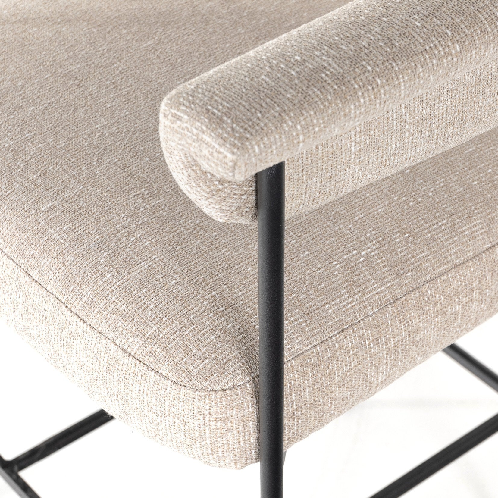 Light camel fabric cushion edge with black metal leg on counter stool