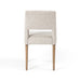 Armless dining chair front view with light camel upholstered back and seat, wooden legs.