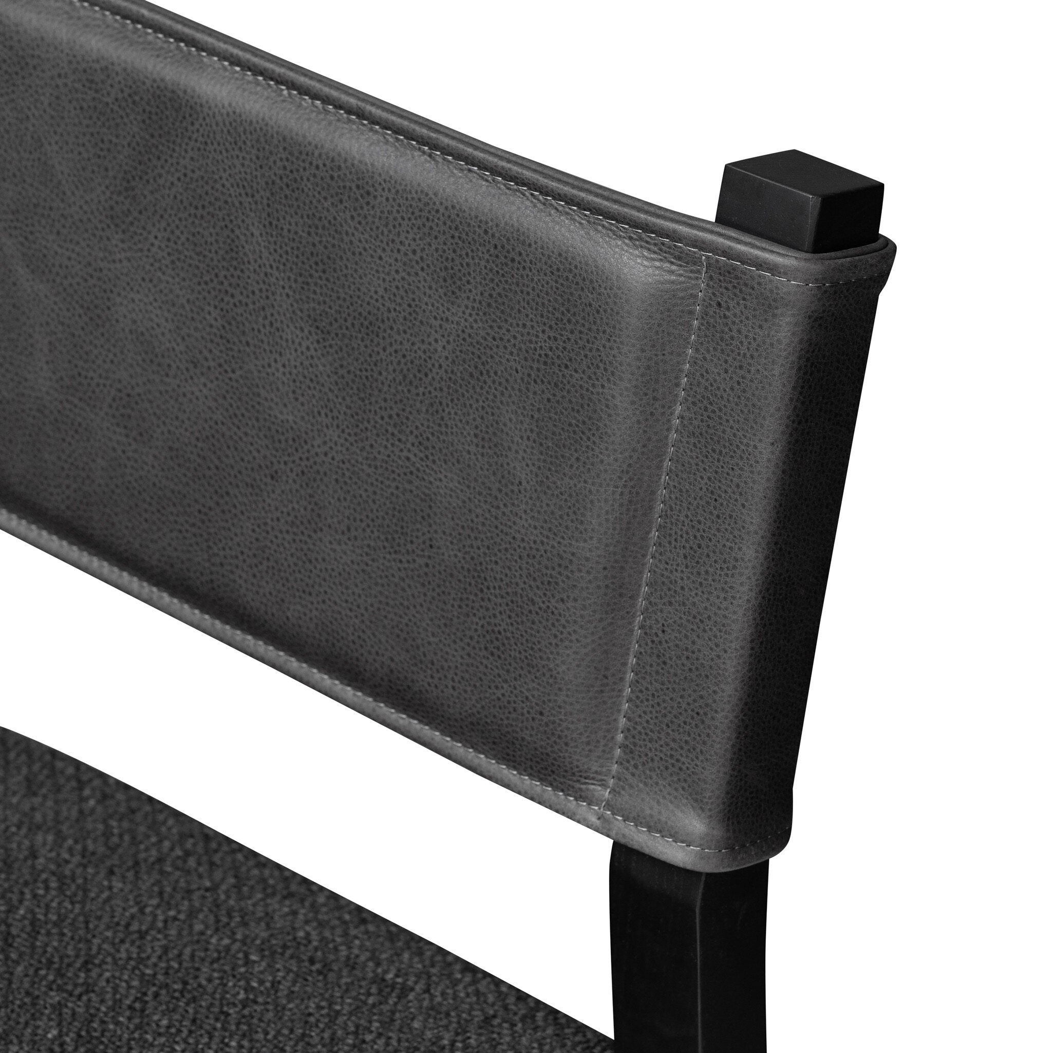 Armless dining chair close-up of dark upholstered back corner and top edge
