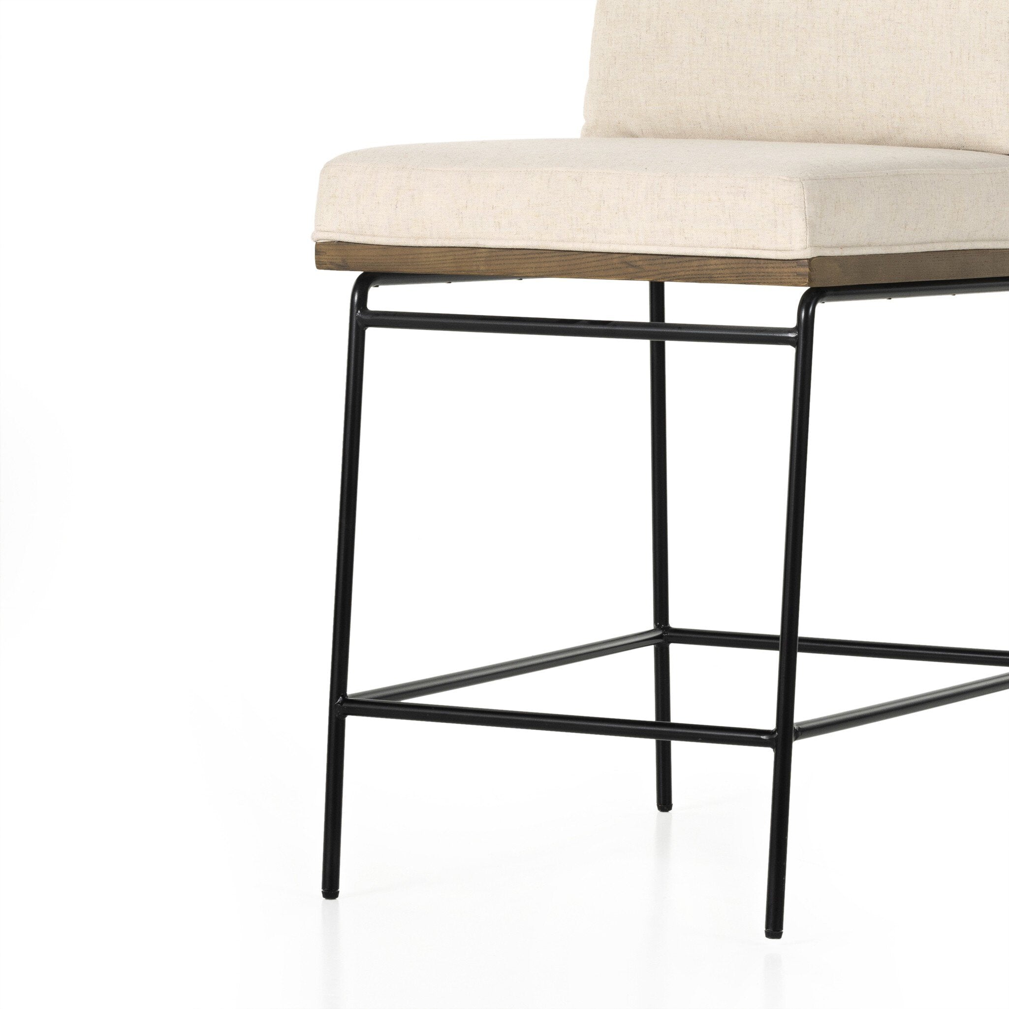 Counter stool with light cream upholstered seat and back, black metal base and footrest