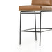 Crete bar stool close side view showing tan seat cushion and black metal base