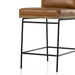 Tan leather counter stool with padded seat, stitched edges, and black metal legs