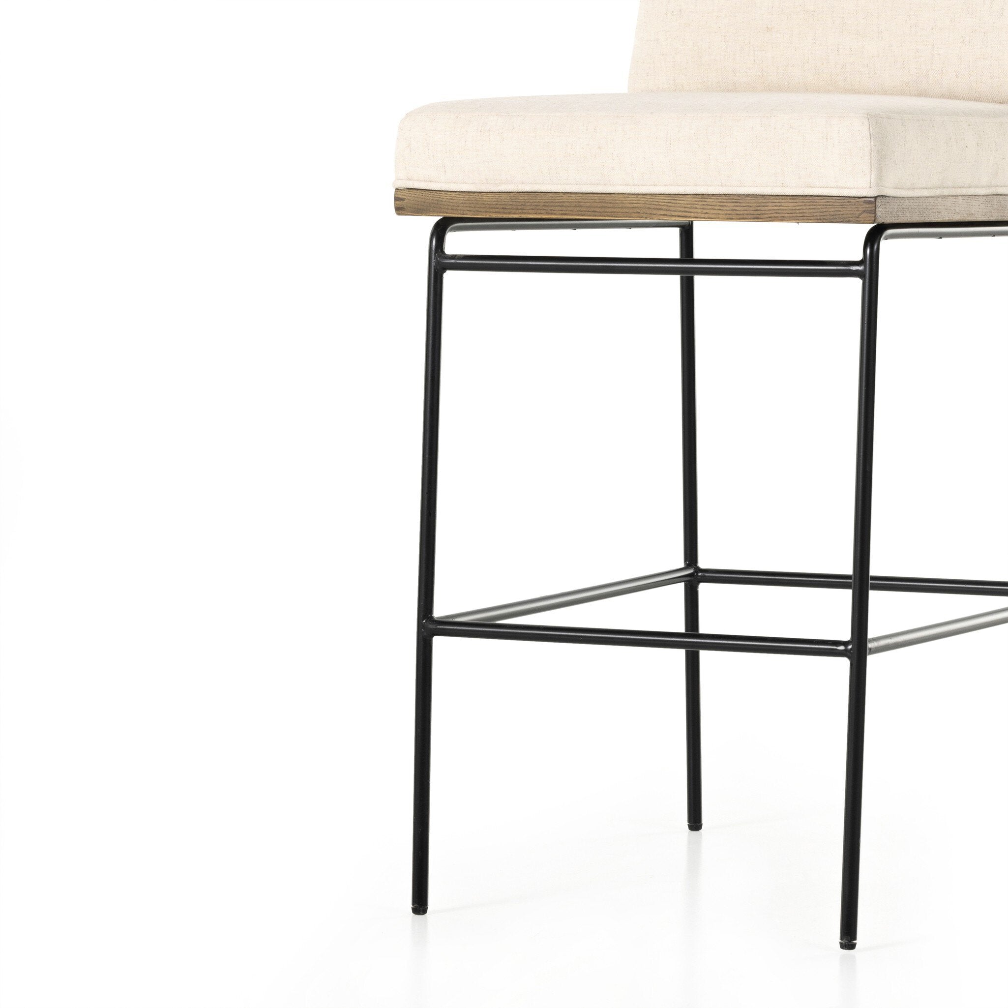 Bar stool with light cushion and black metal base, close front view of frame