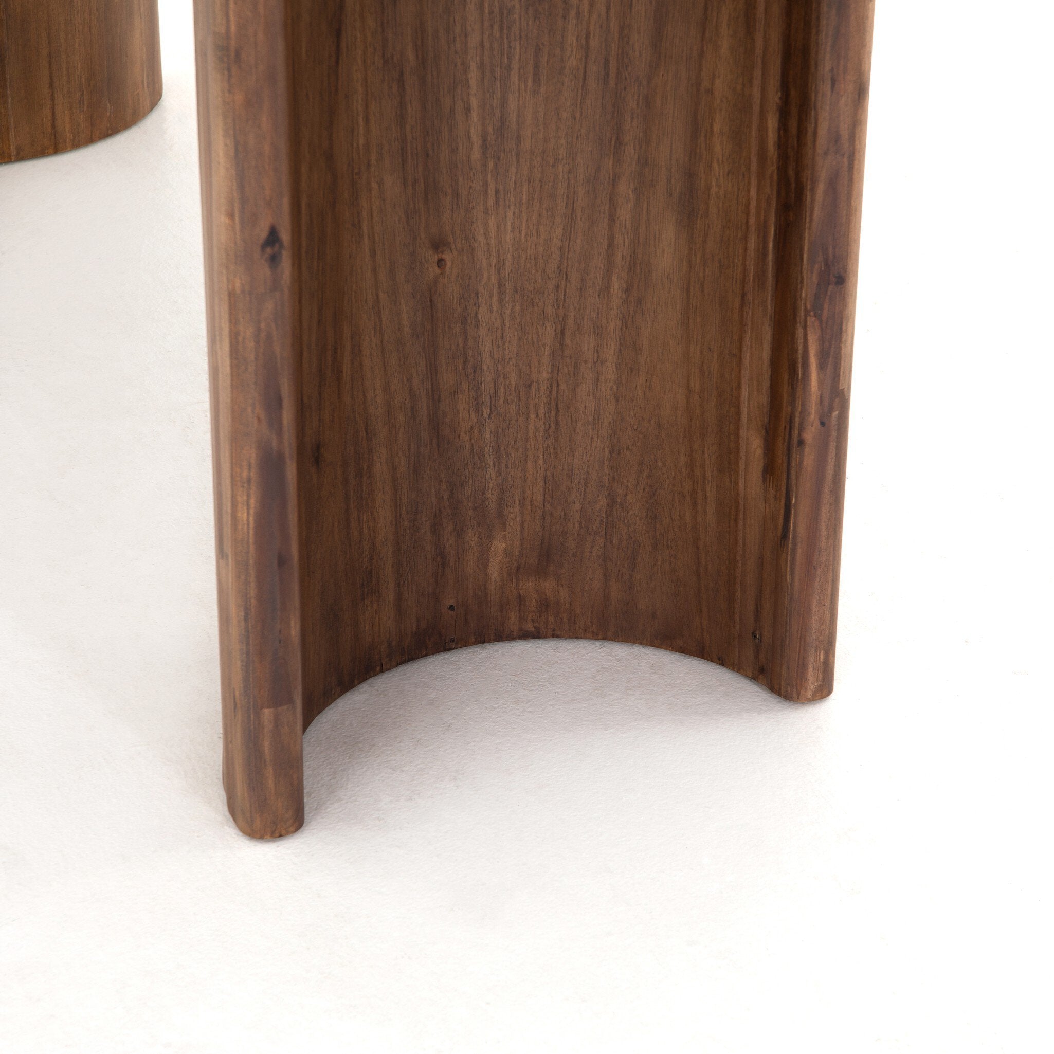 Bottom leg base Paden Dining Table in Seasoned Brown Acacia with crescent-shaped legs and an oval tabletop