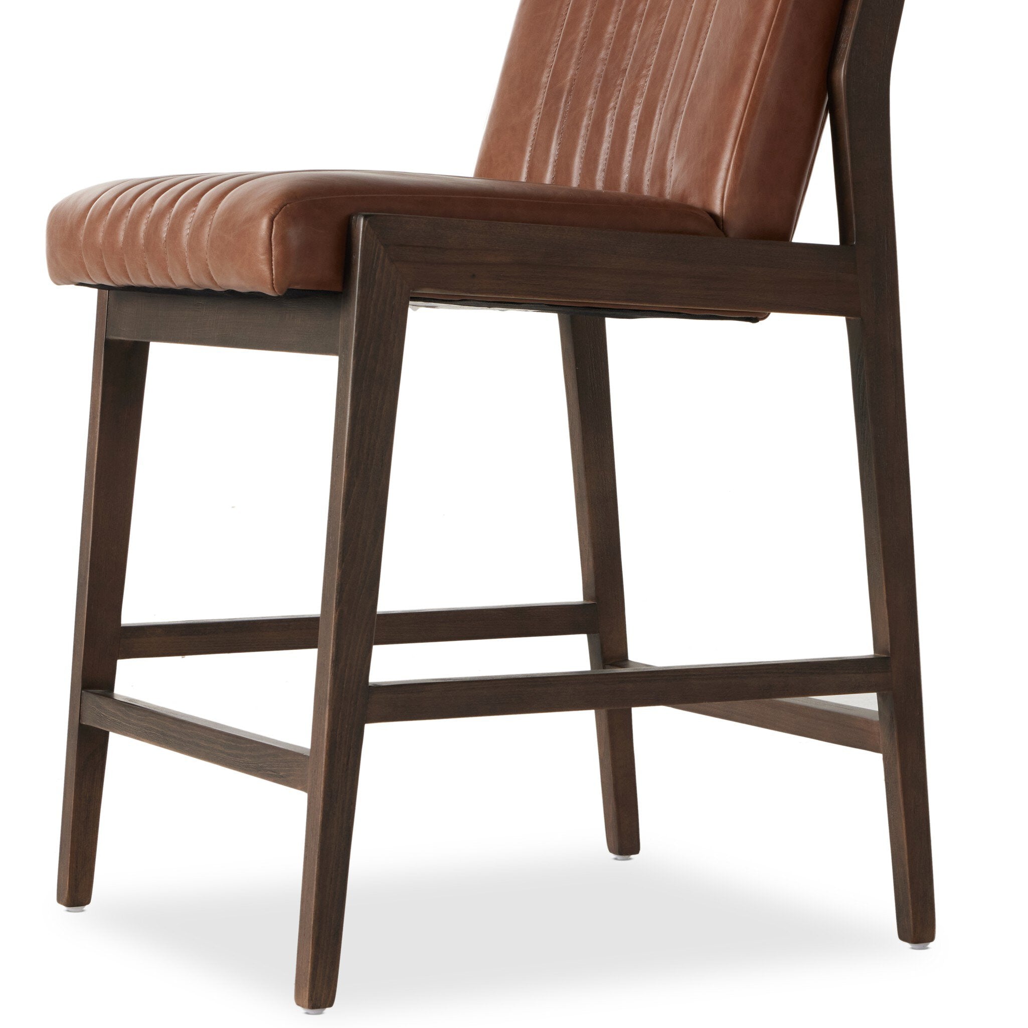 Counter stool with brown upholstered seat and back, visible wood apron and lower crossbar