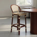 Bar stool with dark wood legs and beige speckled woven seat and back, angled view