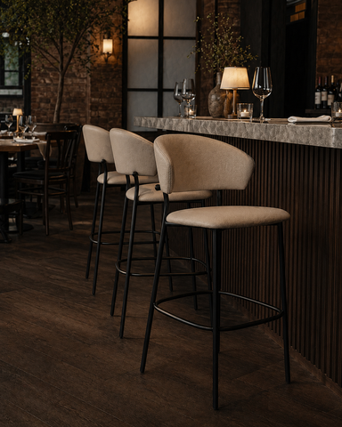 Taupe upholstered bar stool with rounded back, cushioned seat, black metal frame