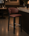 Brown upholstered bar stool with black legs and chrome footrest