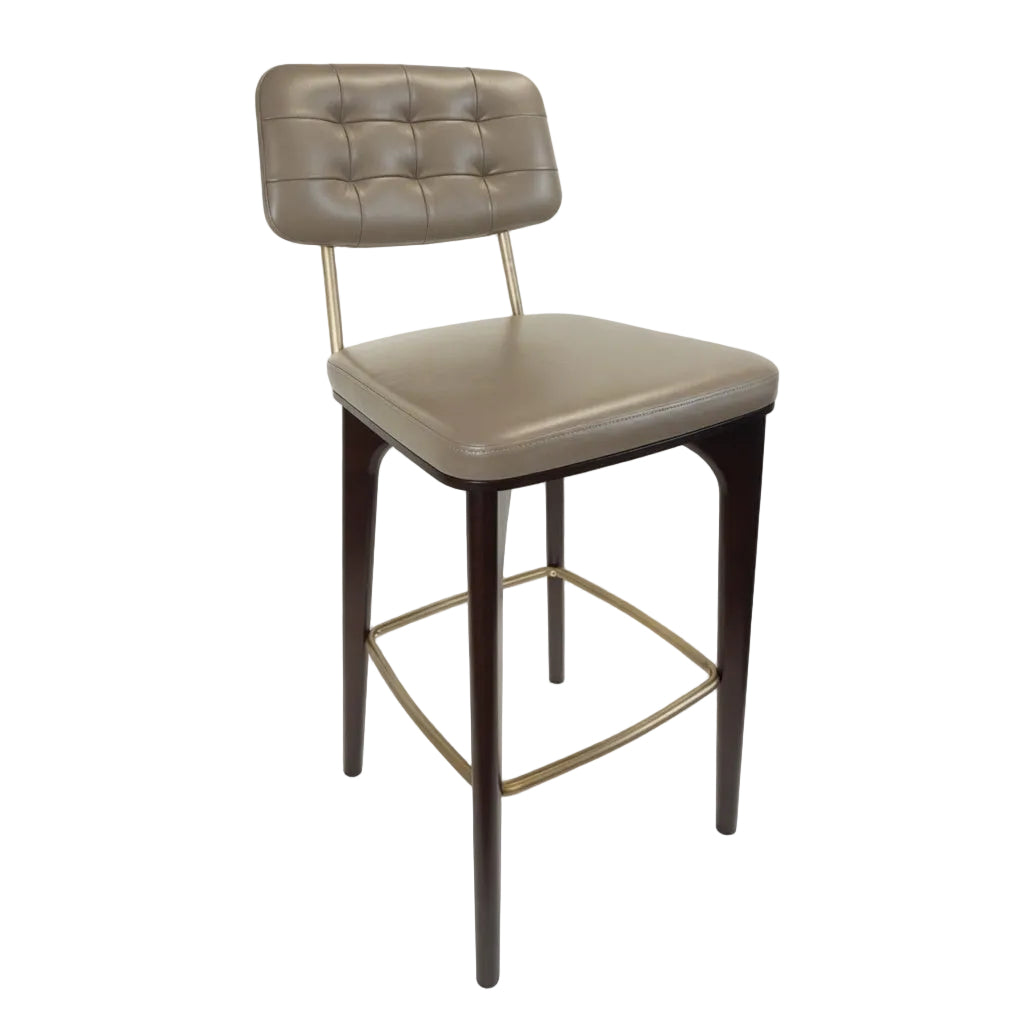 Upholstered bar stool with tufted back and beige seat, dark wood legs and gold footrest frame.