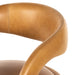 Counter stool close-up of tan upholstered arm and stitched edge with curved contour padding.