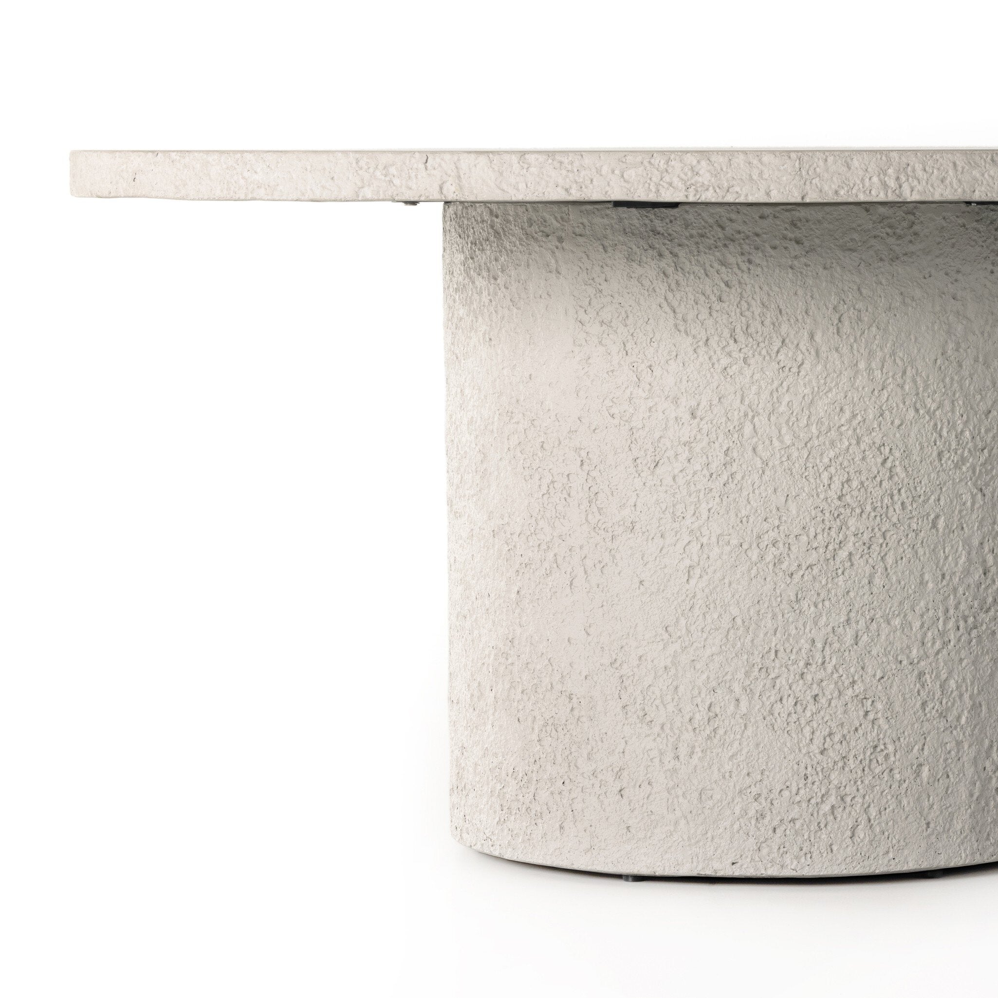 Close-up of Otero outdoor dining table showing raw concrete texture and smooth round tabletop on a white background