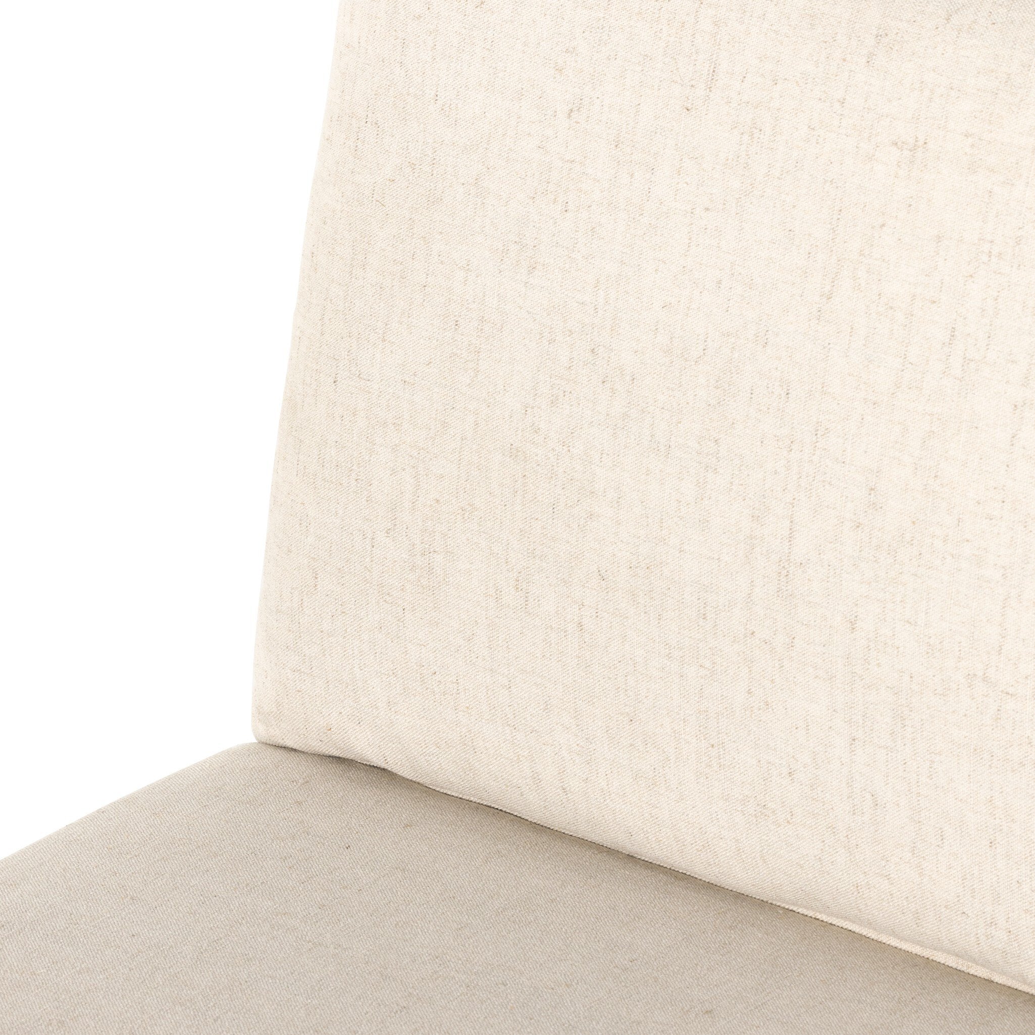 Cream upholstered seat cushion with stitched edge and fabric texture close-up