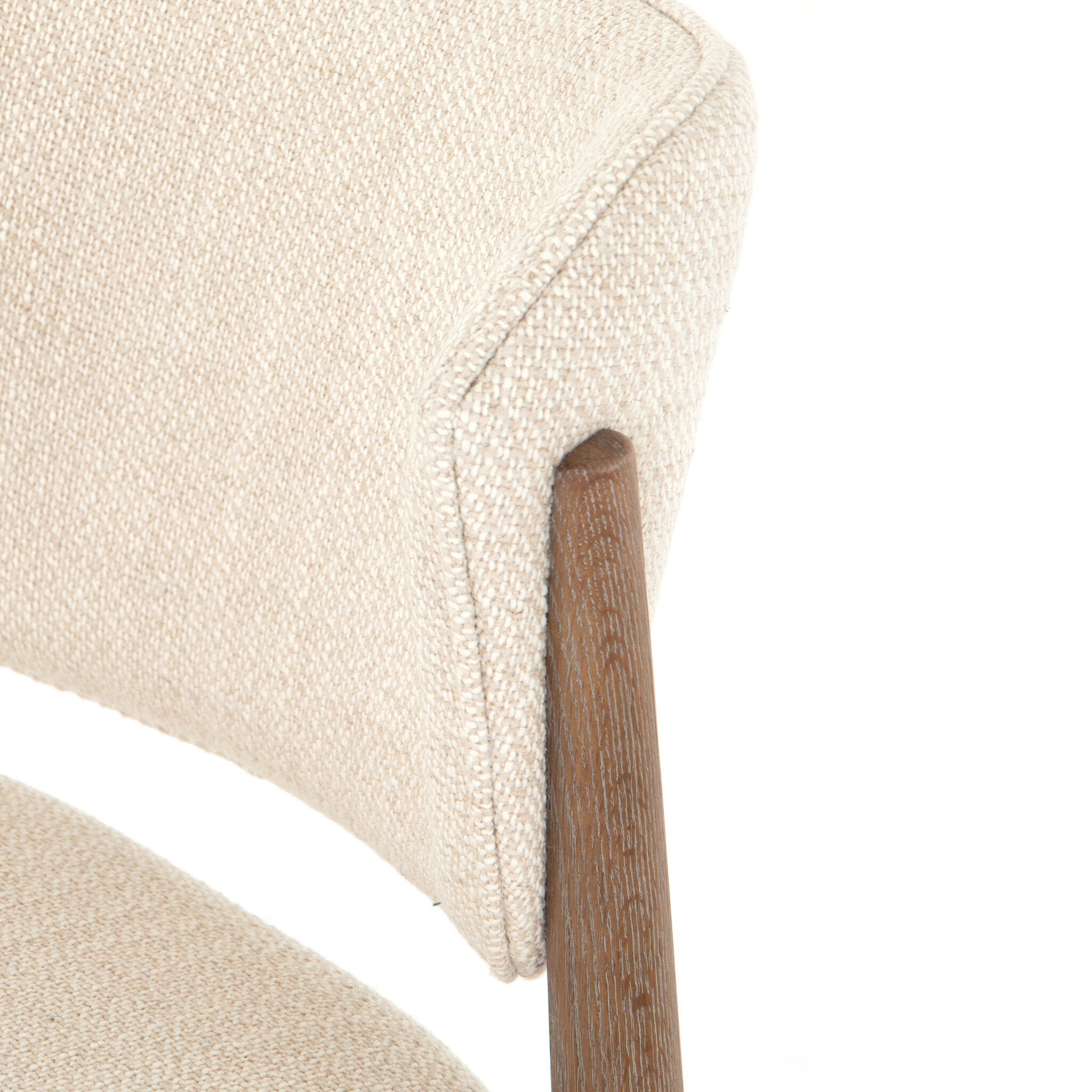 Close-up of a Detail view of Joren Dining Chair showcasing curved wood frame and cushioned seat on white background