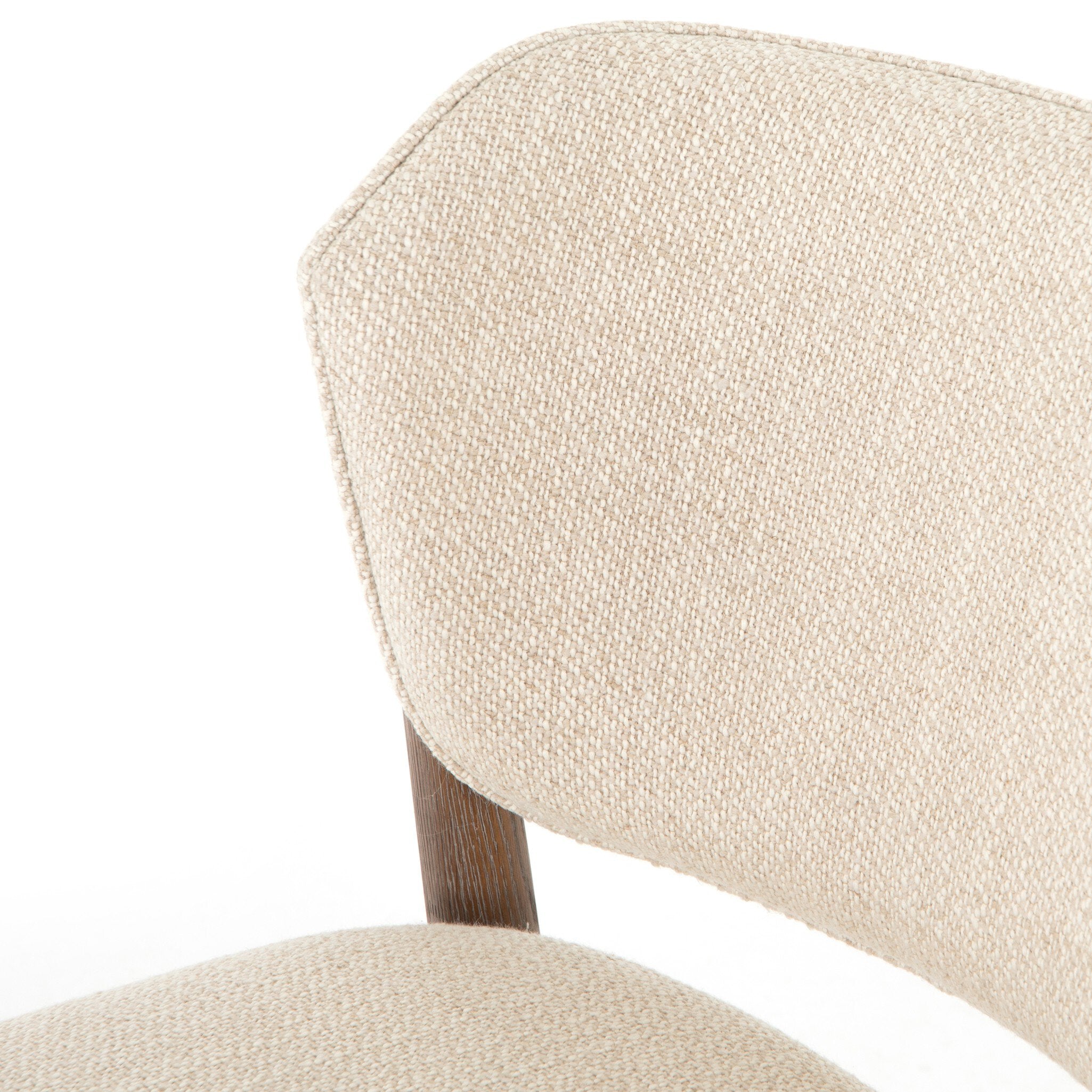 Close-up of a Detail view of Joren Dining Chair showcasing curved wood frame and cushioned seat on white background