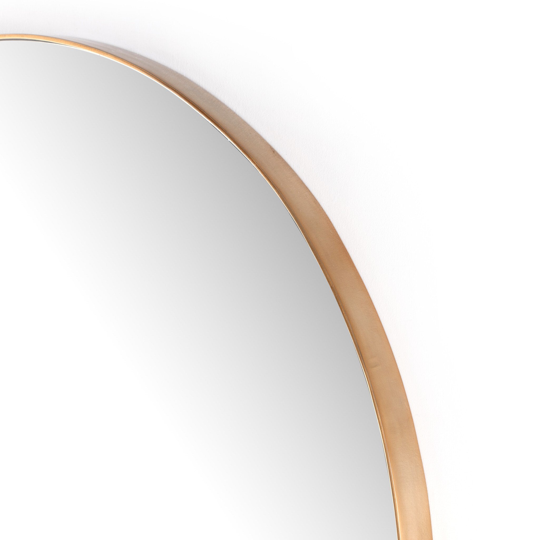 Close-up of the Georgina mirror's slender polished brass frame showing the refined modern edge