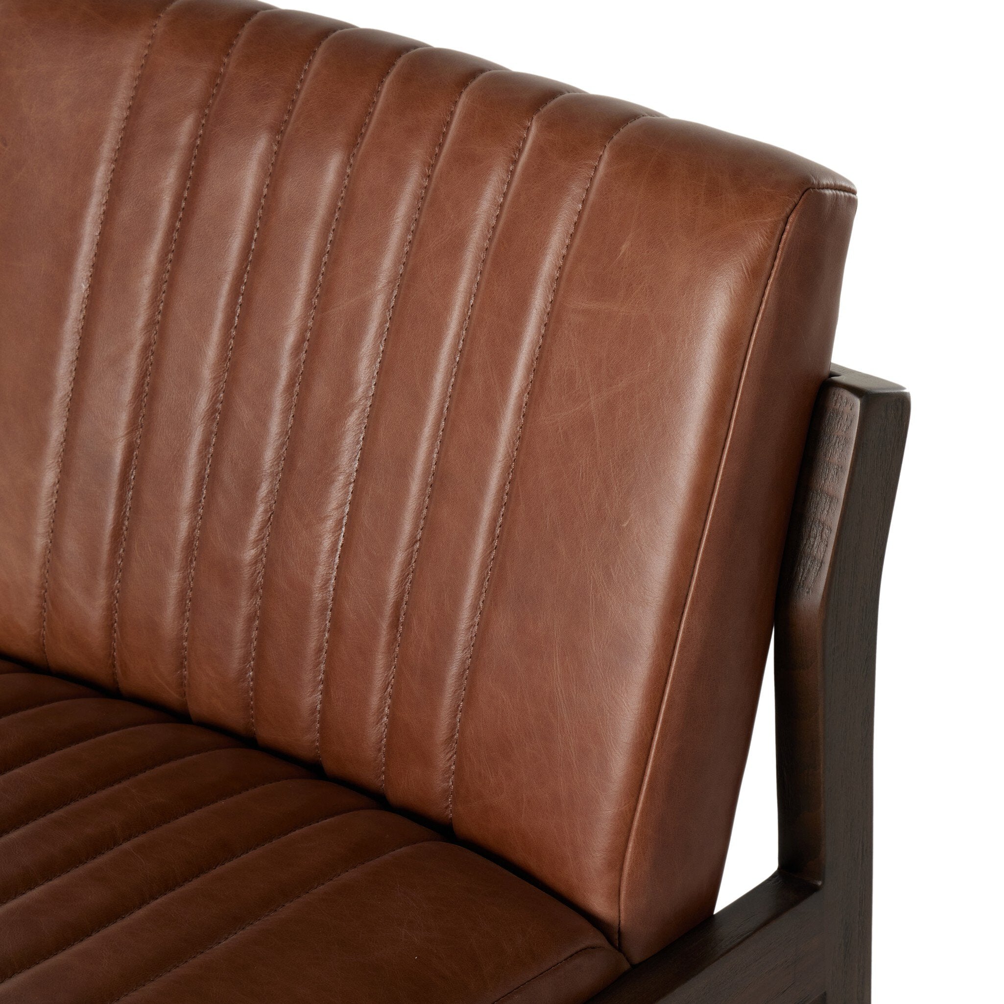 Brown upholstered back panel and arm of counter stool with vertical channel stitching and wood frame