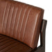 Brown upholstered back panel and arm of counter stool with vertical channel stitching and wood frame