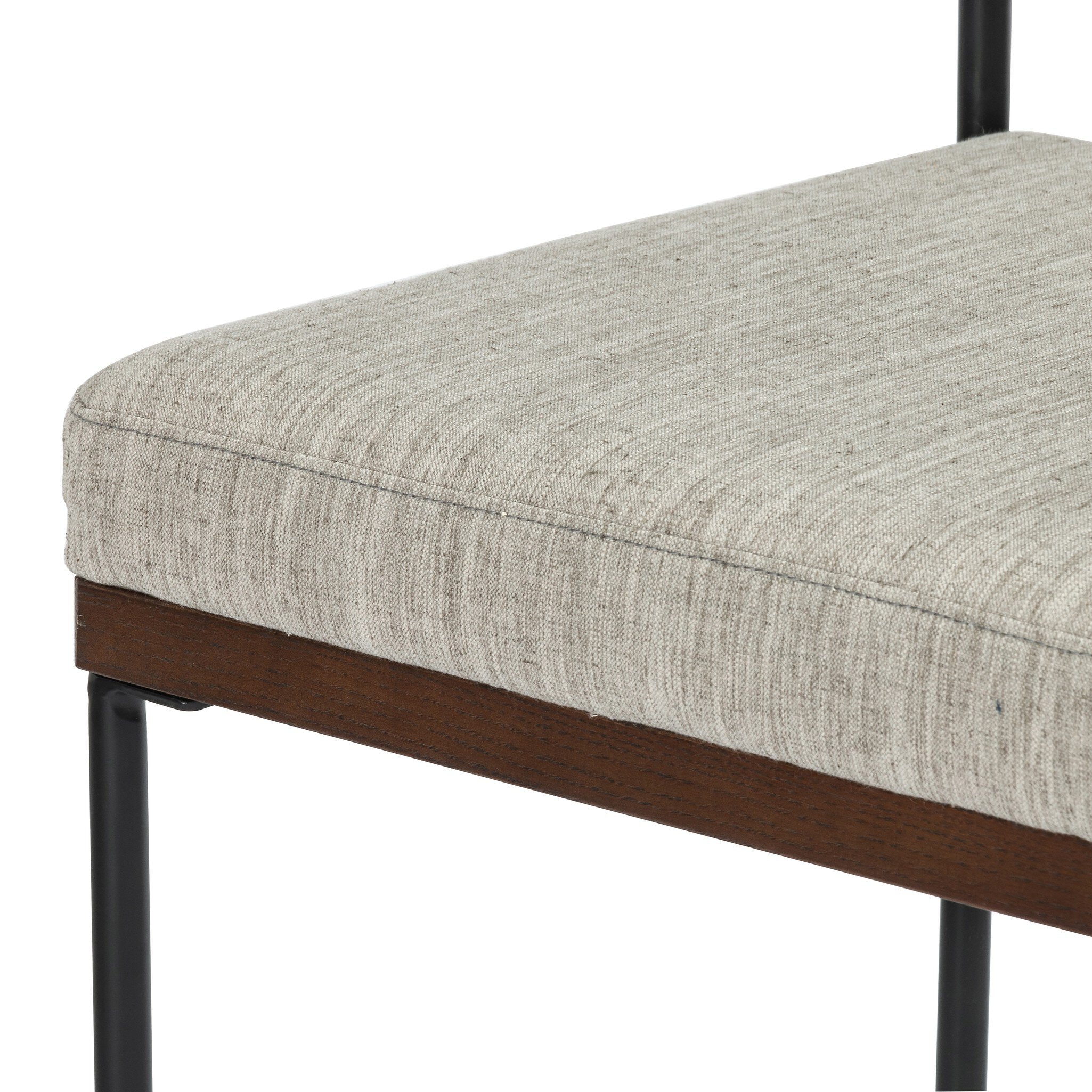 Close-up of light gray upholstered counter stool seat with dark brown wood trim