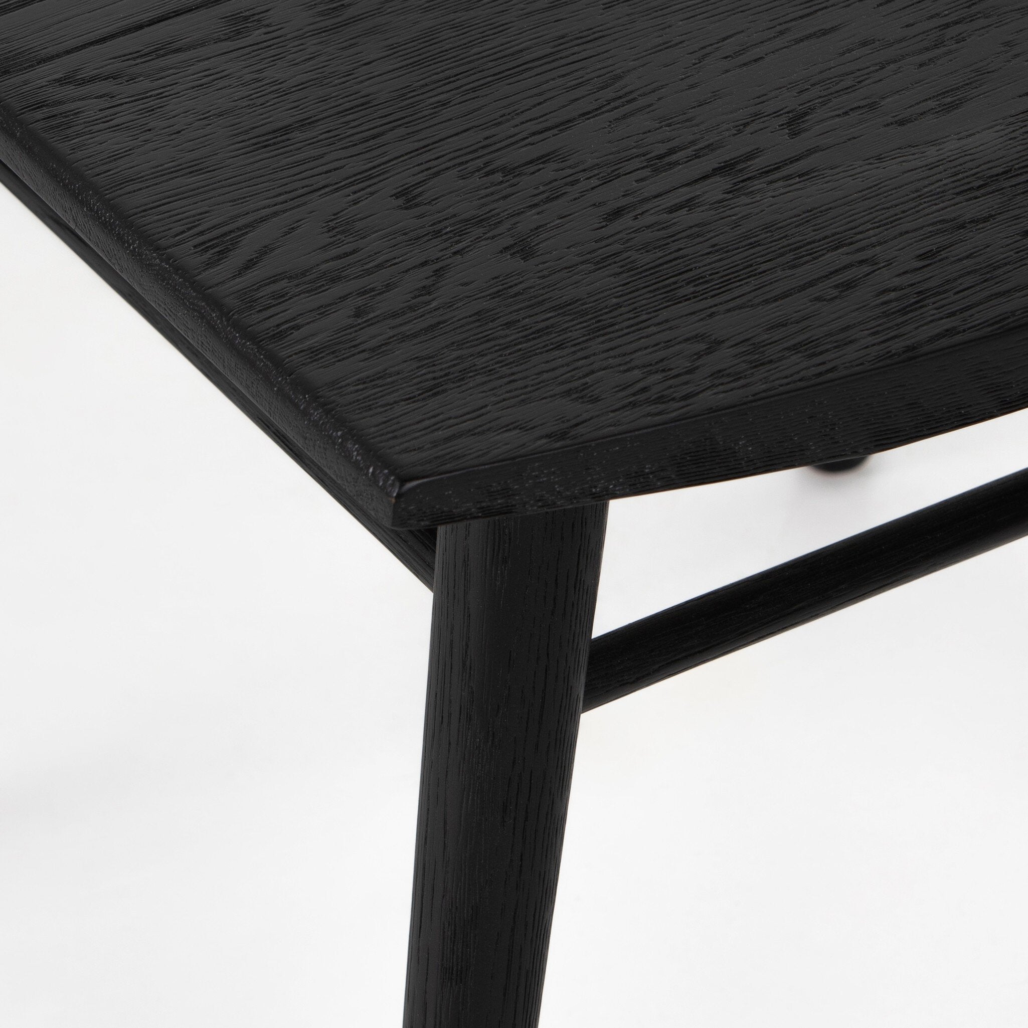 Close-up of dark wood dining chair seat corner and leg with textured grain finish