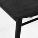 Close-up of dark wood dining chair seat corner and leg with textured grain finish