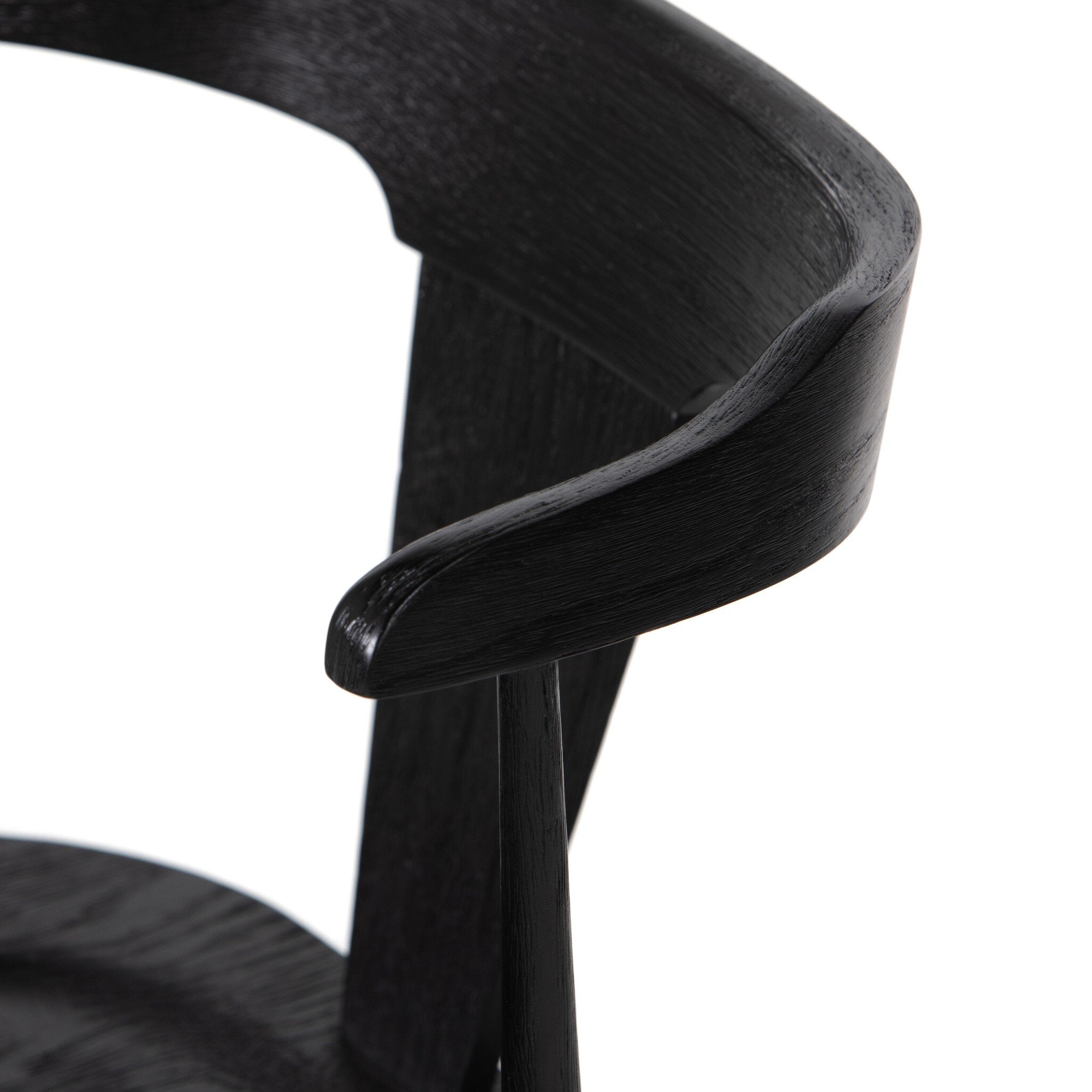 Close-up of a black chair with a white cushion on a white background. Ripley Dining Chair in Black Oak with mid-century Windsor-style sculptural silhouette.