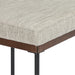 Detail of light gray upholstered cushion with dark brown wood edge and black legs