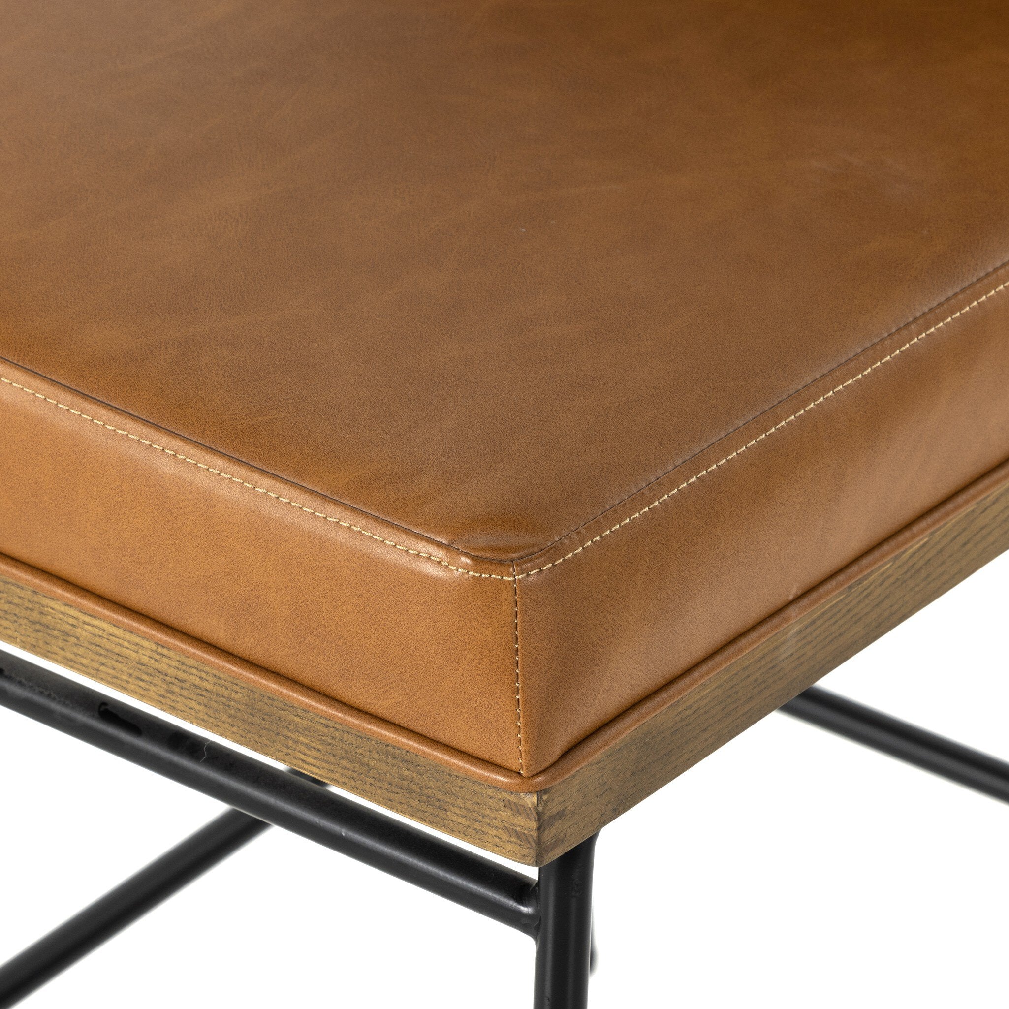 Tan leather counter stool seat with curved corner stitching and light wood frame