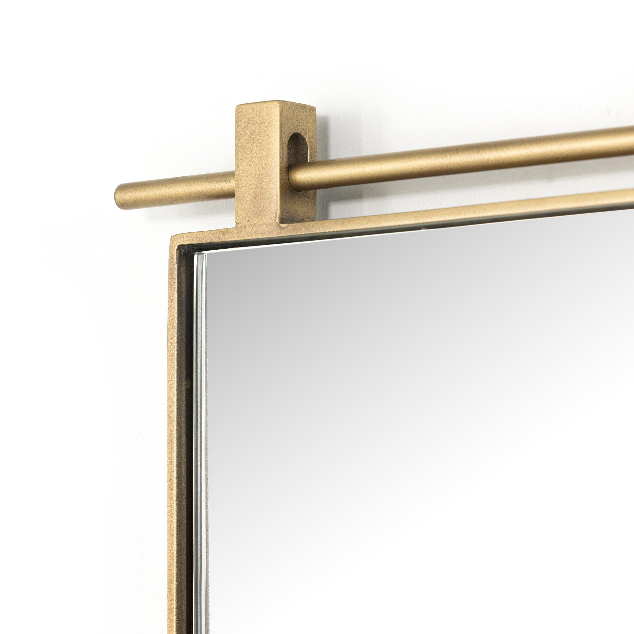 Corner detail Chico small arch wall mirror with a vertical antiqued brass suspension bar