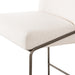 Close-up of light upholstered bar stool seat cushion edge with curved metal trim