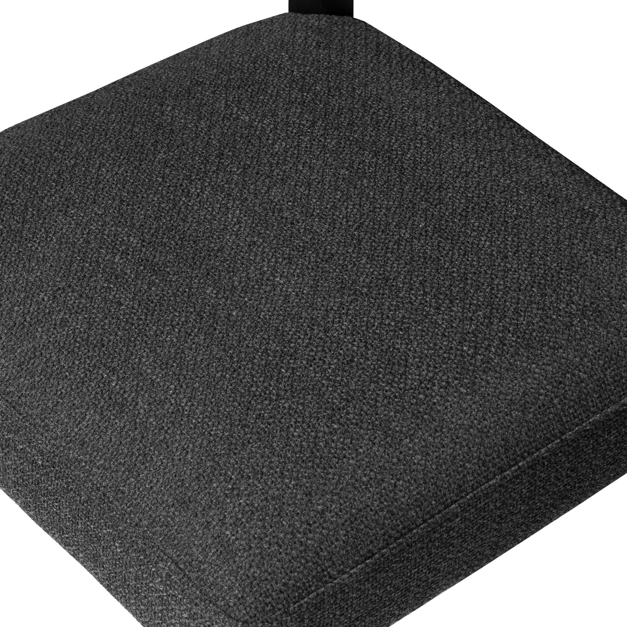 Dark upholstered dining chair seat and back in textured fabric, close-up.