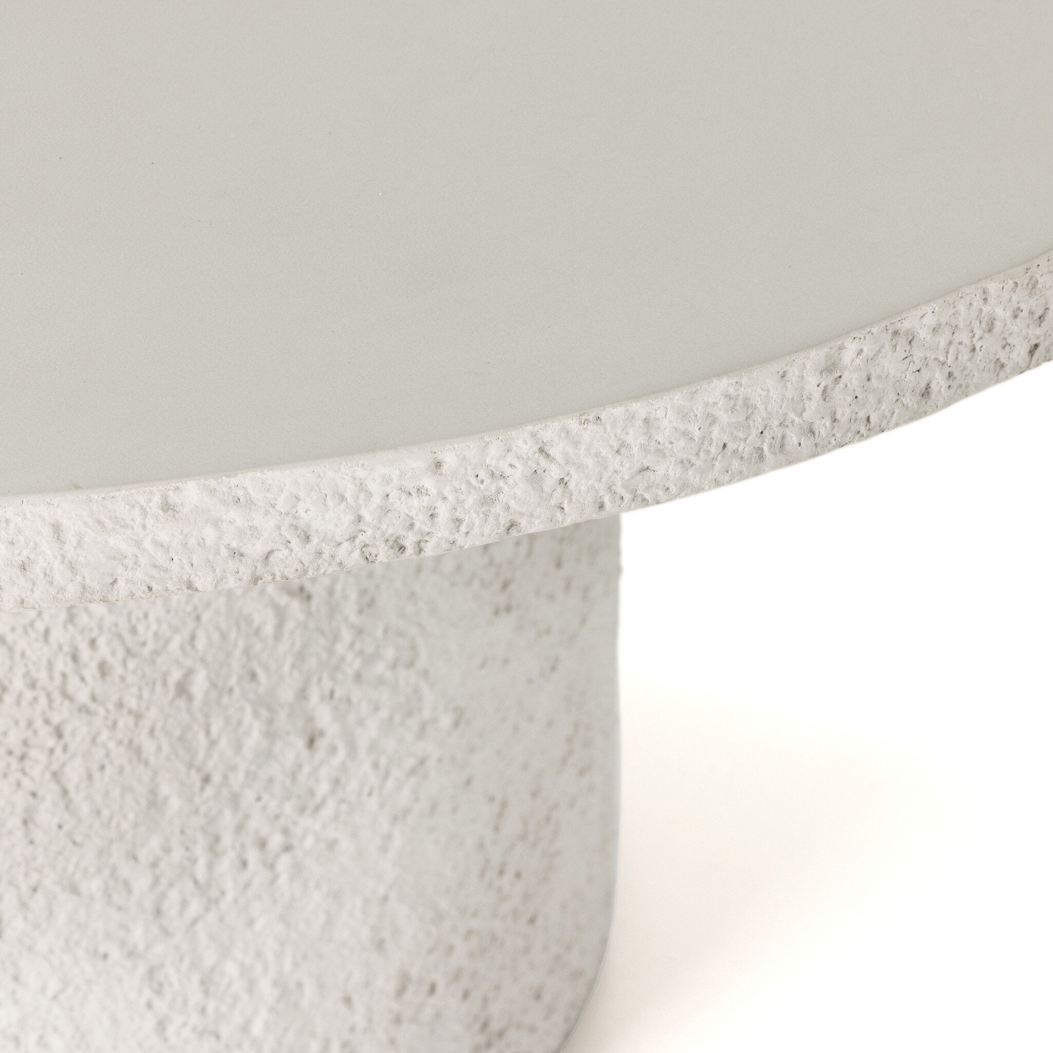Close-up of Otero outdoor dining table showing raw concrete texture and smooth round tabletop