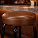 Detailed Crossover Bar Stool by Social Design Supply Co: A modern sculptural steel bar stool with a padded round seat and refined architectural frame for upscale hospitality bars