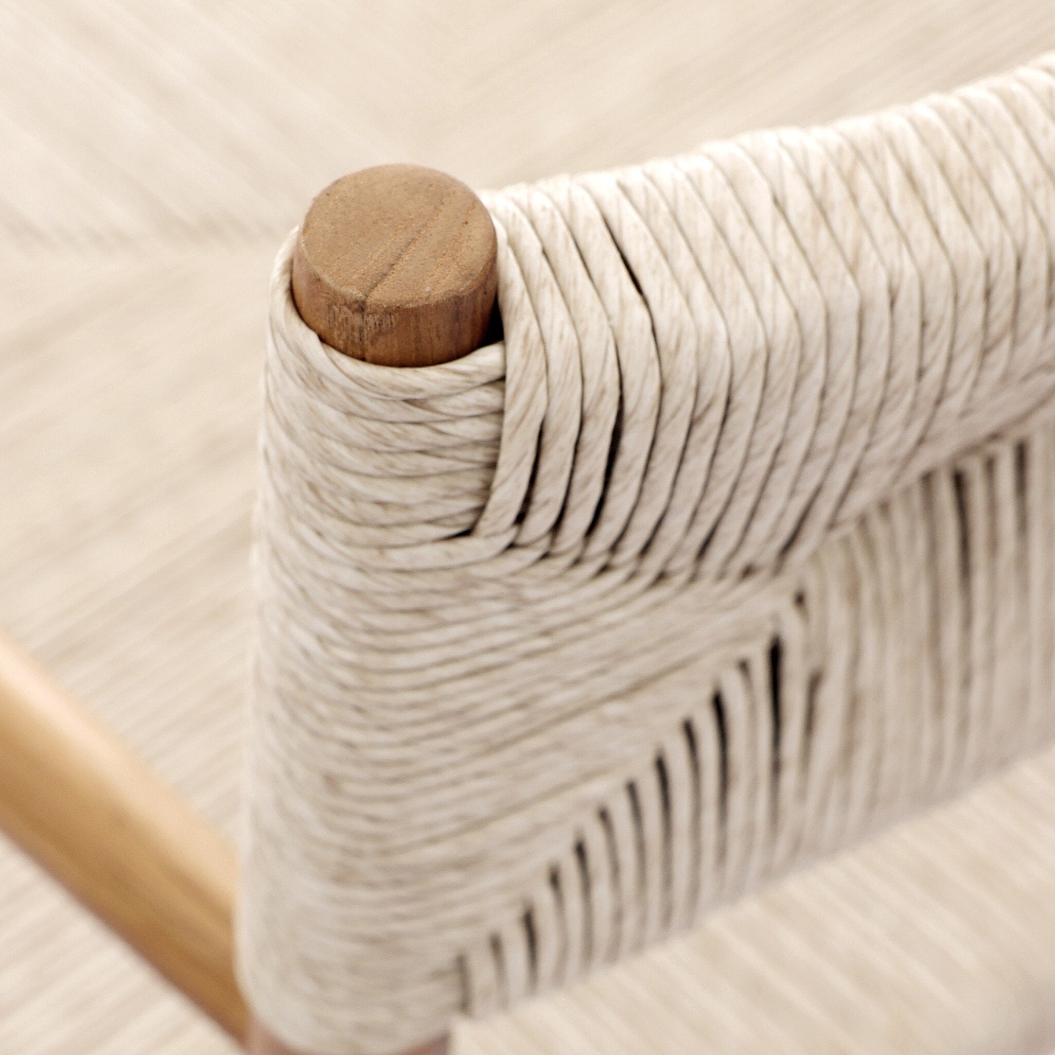 Detailed Lomas Outdoor Dining Armchair in Vintage White woven wicker with a tapered natural teak frame