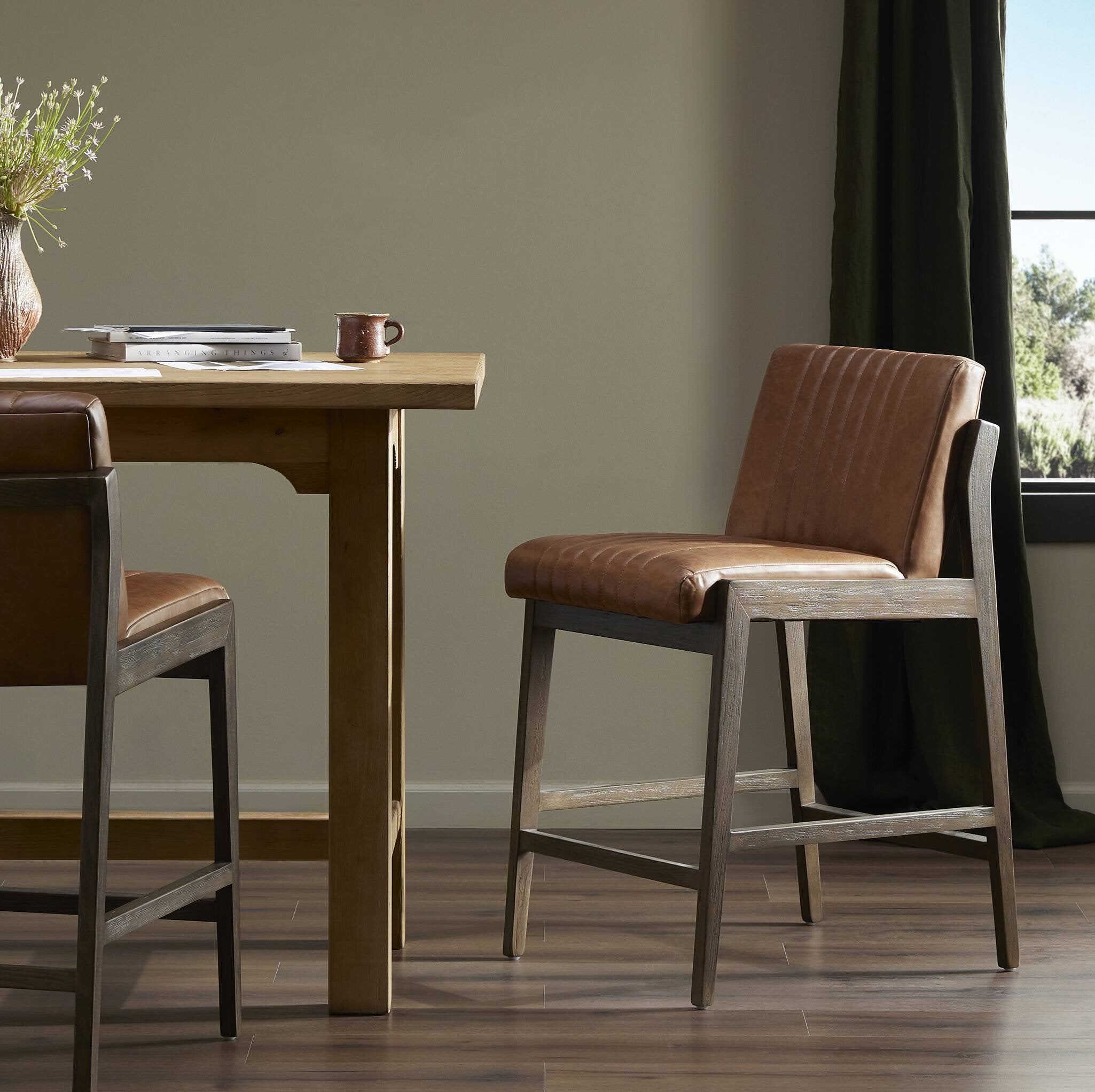 Alice counter stool with brown upholstered seat and back on dark wood legs, open frame