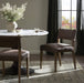 Brown armless dining chair in living room setting, upholstered seat and back, wood legs.