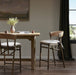 Set of bar stools with light seat cushions and woven backrests on wood frames