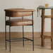 Brown faux-leather counter stool with padded square back, seat, and black metal legs