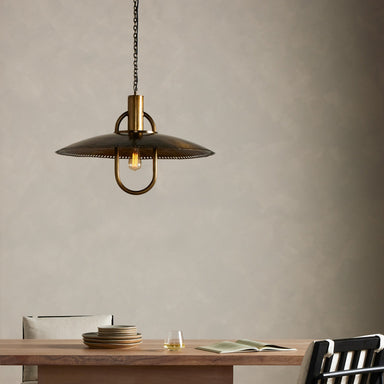Arely 30-inch industrial pendant light in dark antique brass with perforated dome above dining table setting showcasing mid century modern vintage inspiration